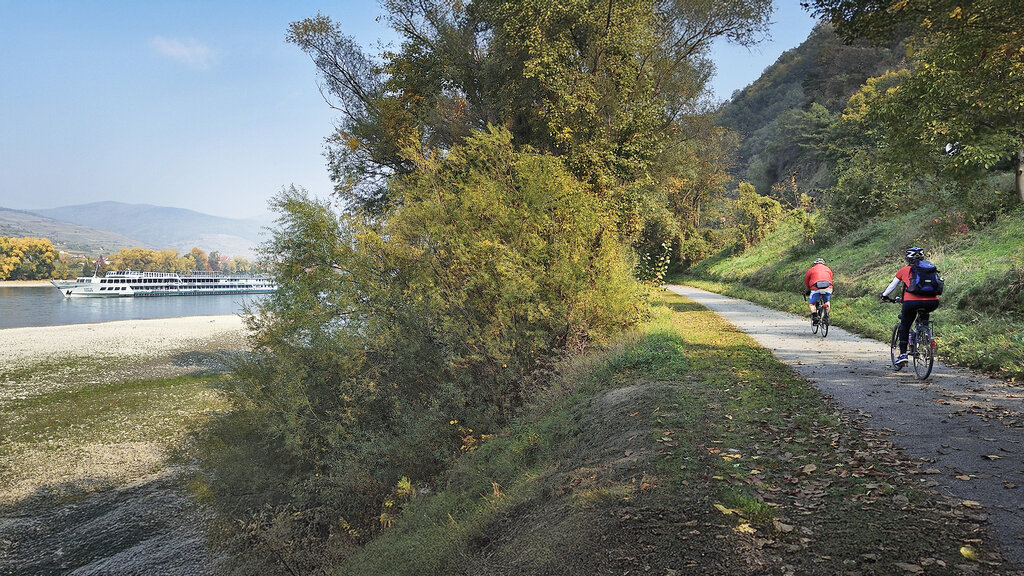 Radweg an der Donau, der Treppelweg. Man sieht zwei Radfahrer:innen.
