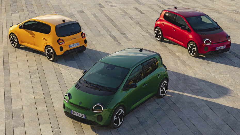 Ein gelber, grüner und roter Renault Twingo stehen auf einem Asphalt-Platz.