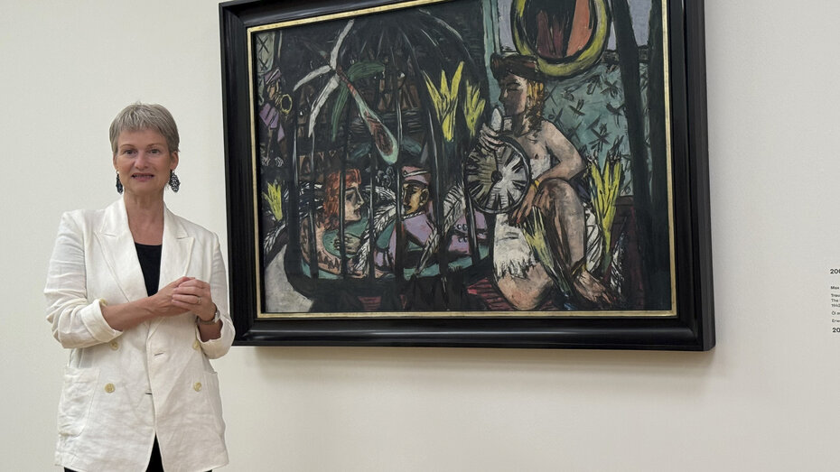 Eine Frau steht vor einem Gemälde.