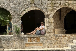 Redakteurin Michaela sitzt in den Arkaden eine Altstadt auf der Insel Hvar.