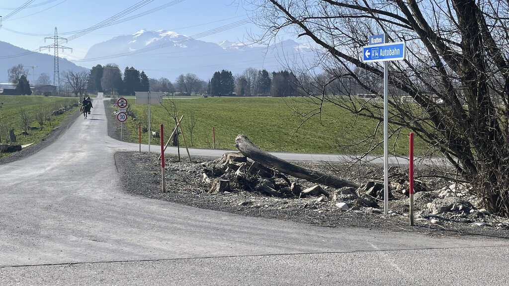 Ein Wegweiser zur Autobahn zeigt in Richtung eines mit Fahrverbot belegten Feldwegs.