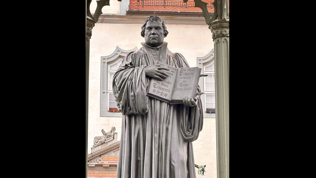 Luther mit der aufgeschlagenen Bibel in Großaufnahme.