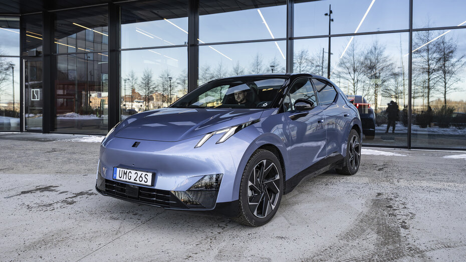 Ein blauer Lynk & Co 02 steht vor einer Fensterfront.