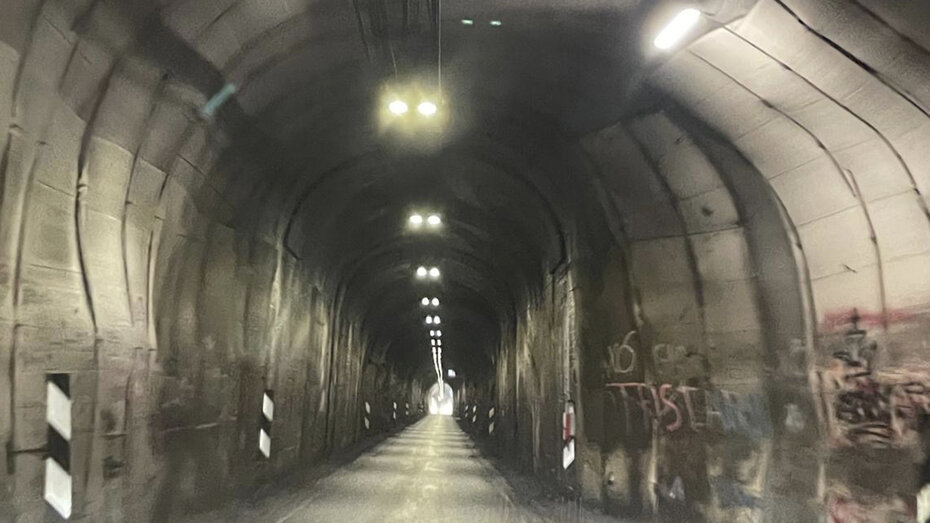 ein dunkler Tunnel mit nur einer Fahrbahn 