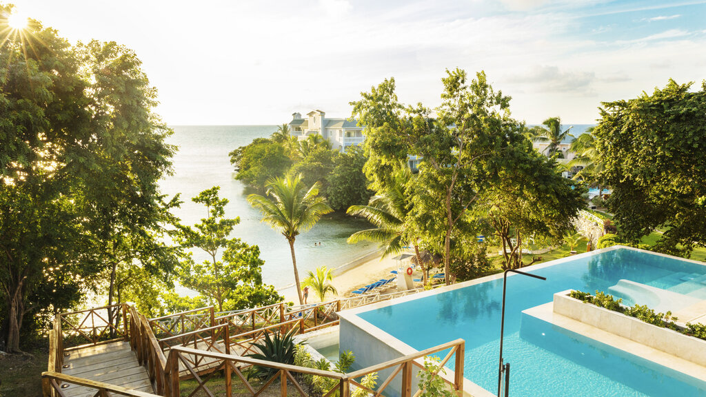 Poollandschaft mit Blick aufs Meer und den Strand.