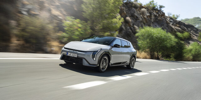 Ein grauer Kia EV4 fährt auf einer Landstraße.