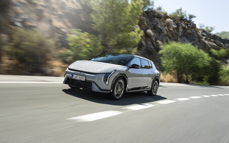 Ein grauer Kia EV4 fährt auf einer Landstraße.