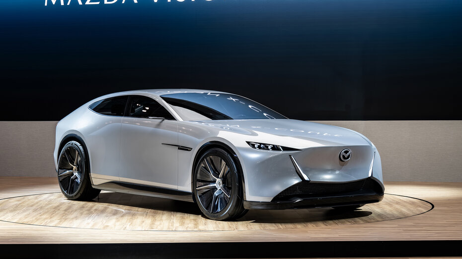 Eine silberne Limousine von Mazda steht auf einer Bühne