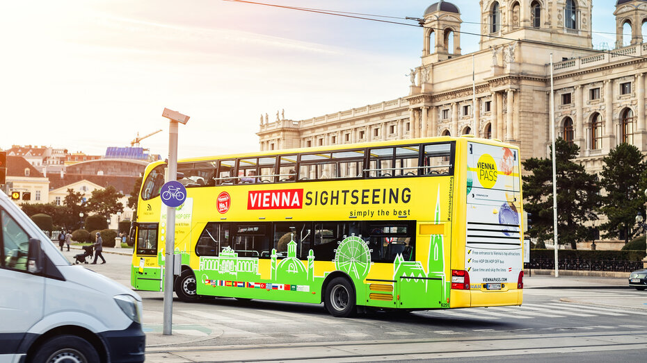 Ein Hop on, hop off Bus fährt in Wien am Kunsthistorischen Museum vorbei.