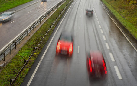 Verschwommenes Bild eines Geisterfahrers in einem roten Auto auf der Autobahn