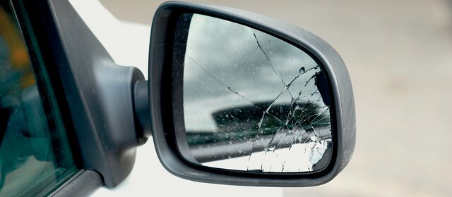 Der beschädigte Außenspiegel eines weißen Autos