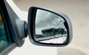 Der beschädigte Außenspiegel eines weißen Autos