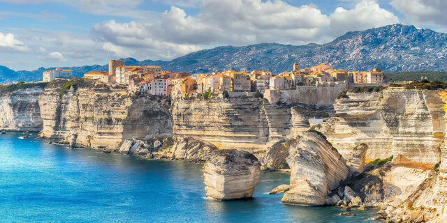 Das Meer mit atemberaubenden Klippen, darauf thront eine kleine Stadt.