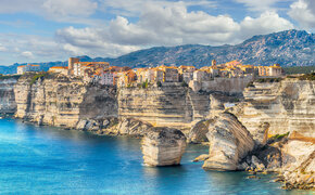 Das Meer mit atemberaubenden Klippen, darauf thront eine kleine Stadt.