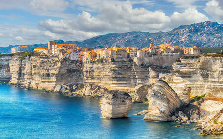 Das Meer mit atemberaubenden Klippen, darauf thront eine kleine Stadt.