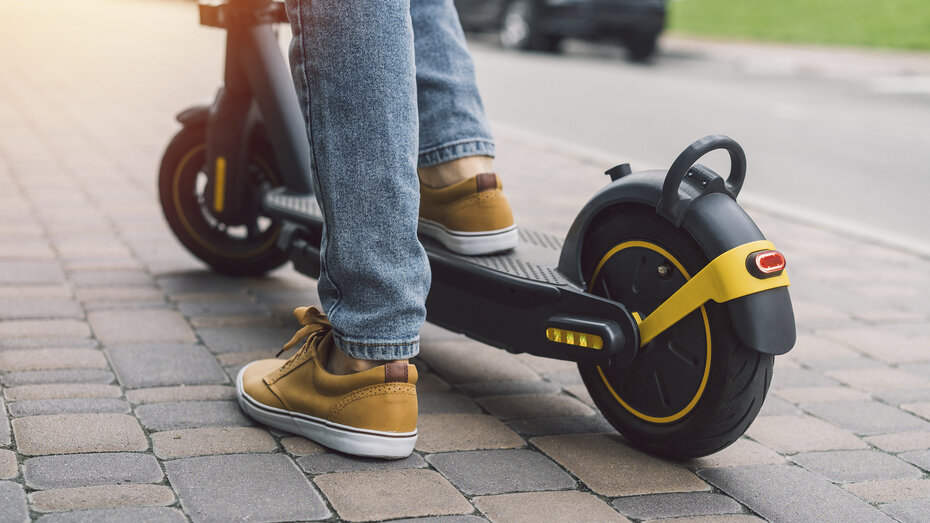 Jemand steht auf einem E-Scooter