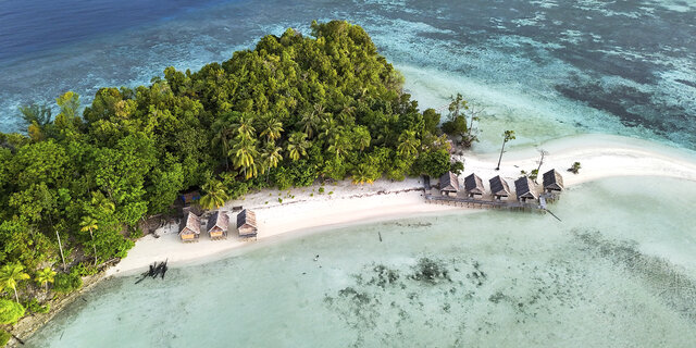 Luftaufnahme von Kri Island, Raja Ampat, Indonesien mit tropischem Strand, Meer und Überwasser-Bungalows