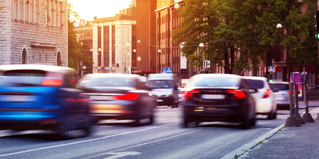 Autos fahren bei Sonnenuntergang durch die Stadt