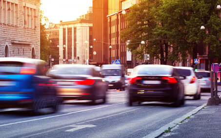Autos fahren bei Sonnenuntergang durch die Stadt