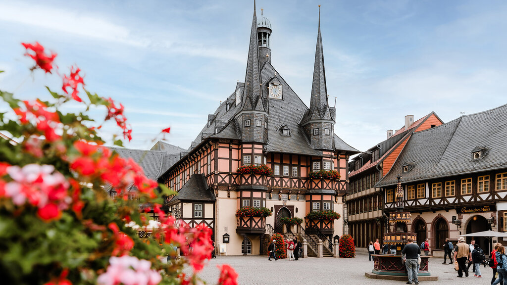 Ein großes Fachwerkhaus mit zwei Türmen und einem mittigen Eingang über Stufen.