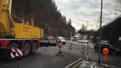 Baustellenfahrzeug und ein Bauarbeiter auf der Straße vor der Absperrung des Kreisverkehrs Innsbruck Mitte