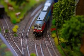 Modelleisenbahn auf Gleisen mit Miniaturbäumen