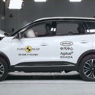 ÖAMTC-Crashtest: Chery Tiggo 7 Das Foto zeigt ein weißes Auto von der Seite, das gerade im Zuge eines Crashtests frontal gegen ein Hindernis prallt.