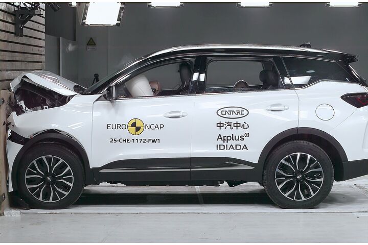 Das Foto zeigt ein weißes Auto von der Seite, das gerade im Zuge eines Crashtests frontal gegen ein Hindernis prallt.