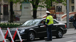 Polizist der ein Auto vor einem gesperrten Straßenabschnitt anhält.