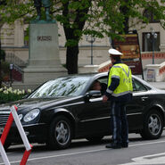 Polizist der ein Auto vor einem gesperrten Straßenabschnitt anhält.