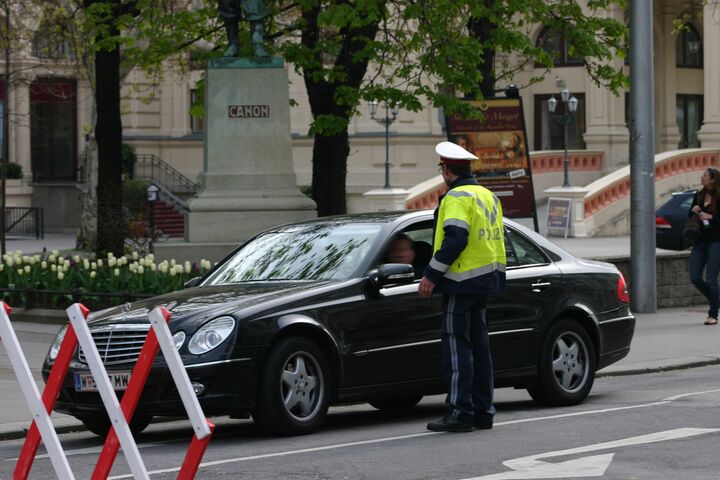 Polizist der ein Auto vor einem gesperrten Straßenabschnitt anhält.