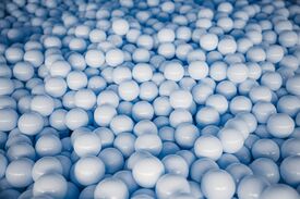 Viele hellblaue Plastikbälle in einem Bällebad