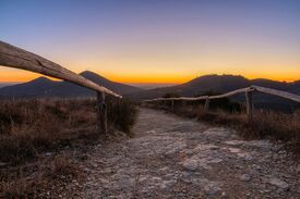 Ein Wanderweg bei Sonnenuntergang mit Berg im Hintergrund