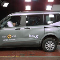 Das Foto zeigt ein graues Auto von der Seite, das gerade im Zuge eines Crashtests frontal gegen ein Hindernis prallt.