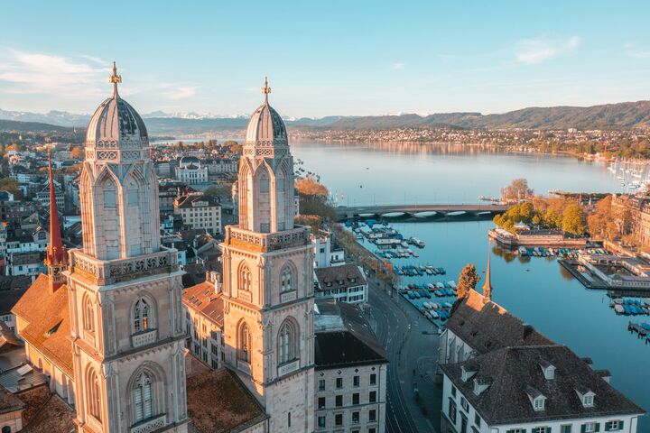 Blick auf die zwei Türme des Grossmünster mit dem Zürichersee im Hintergrund