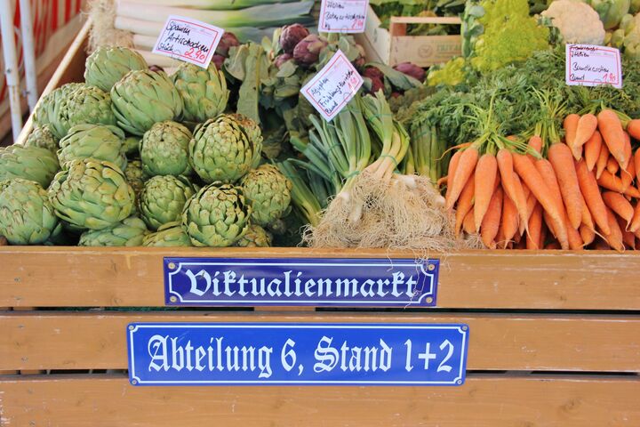 Gemüse auf einem Markt mit zwei Schildern