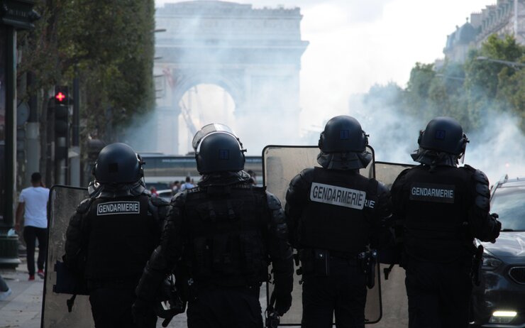 Vier Polizisten in Paris bei einem Protest vor dem Triumphbogen