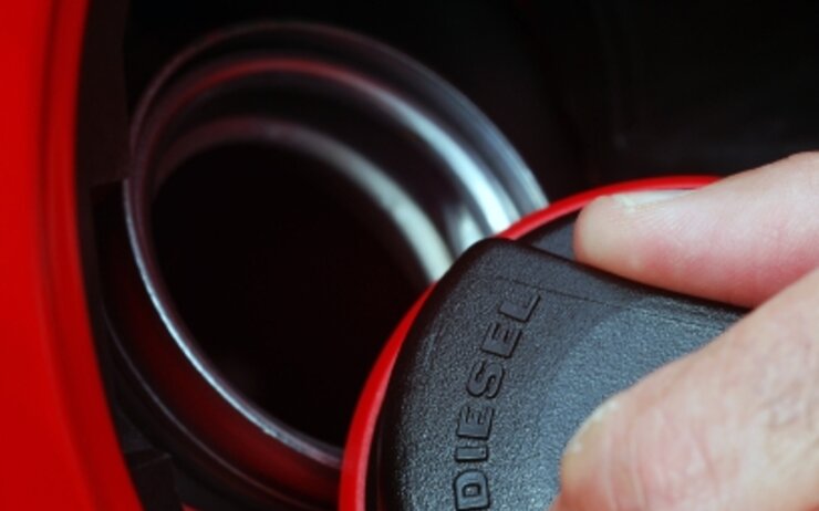 Tankdeckel Diesel Ein Tankdeckel von einem Dieselfahrzeug wird ein einer Hand geöffnet.