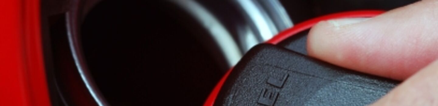 Ein Tankdeckel von einem Dieselfahrzeug wird ein einer Hand geöffnet.