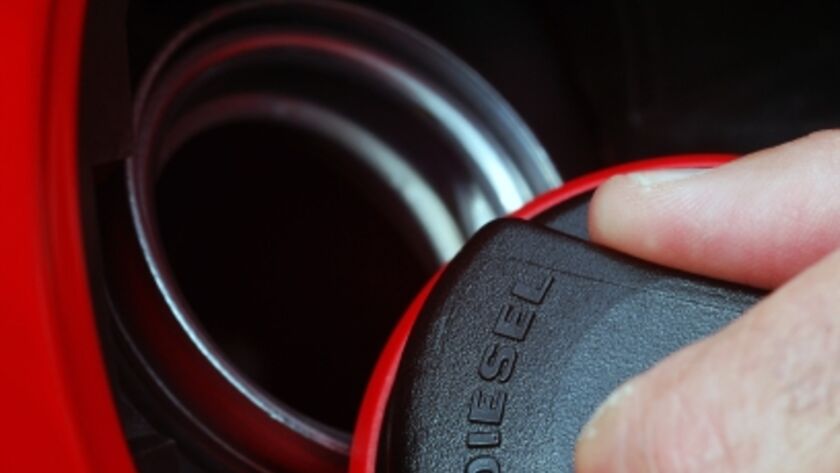 Ein Tankdeckel von einem Dieselfahrzeug wird ein einer Hand geöffnet.