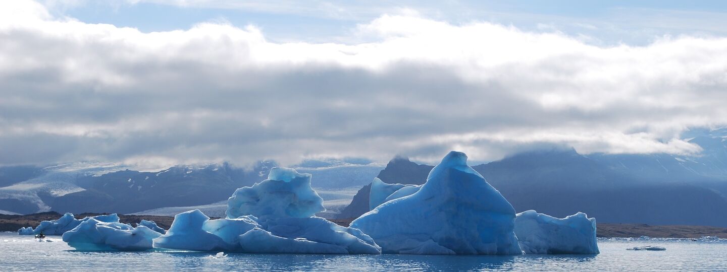 Schwimmender Eisberg in einer Gletscherlagune Islands mit spiegelglattem Wasser und eindrucksvoller Eismasse im Fokus