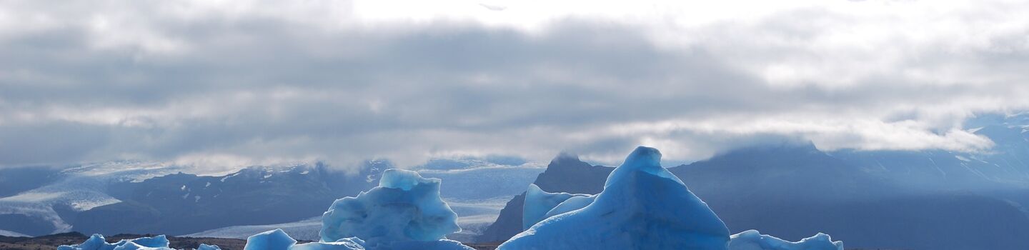 Schwimmender Eisberg in einer Gletscherlagune Islands mit spiegelglattem Wasser und eindrucksvoller Eismasse im Fokus