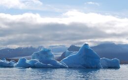 Schwimmender Eisberg in einer Gletscherlagune Islands mit spiegelglattem Wasser und eindrucksvoller Eismasse im Fokus