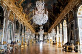 Ein prunkvoller Saal im Schloss Versailles mit einem großen Luster