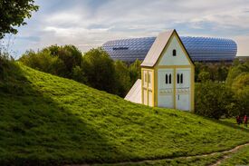 eine kleine Kapelle mit der Allianz Arena in München im Hintergrund