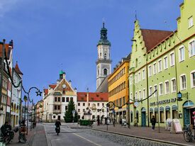 Bunte Häuser und eine Kirche an einer gepflasterten Straße