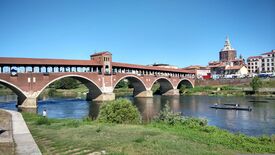 eine überdachte Brücke über einem Fluss in Pavia