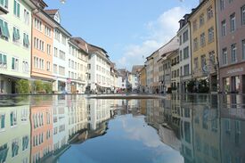 Stadtzentrum Winterthur mit bunten historischen Häusern, die sich in einer Lacke spiegeln