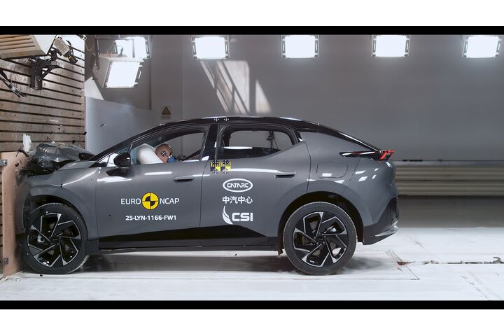 Das Foto zeigt ein graues Auto von der Seite, das gerade im Zuge eines Crashtests frontal gegen ein Hindernis prallt.