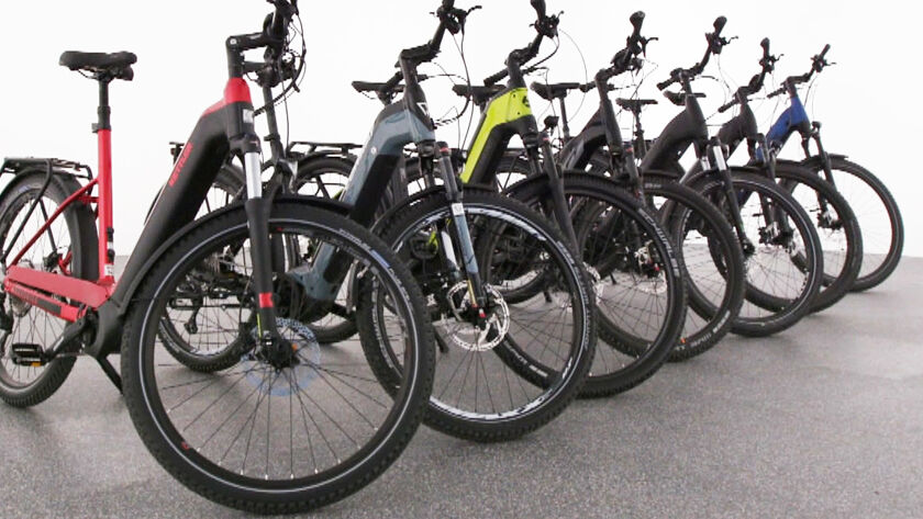 7 Offroad-E-Bikes stehen aufgereiht seitlich im Bild.
